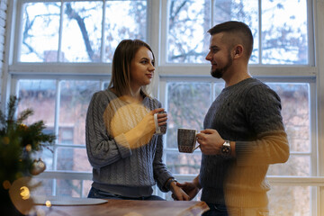 girl and guy in the kitchen with a mug of tea