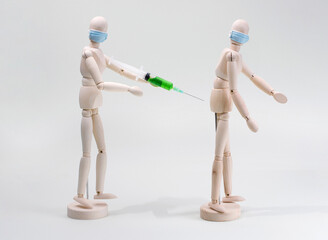 a wooden model of a human being vaccinated or injected into another person's buttock