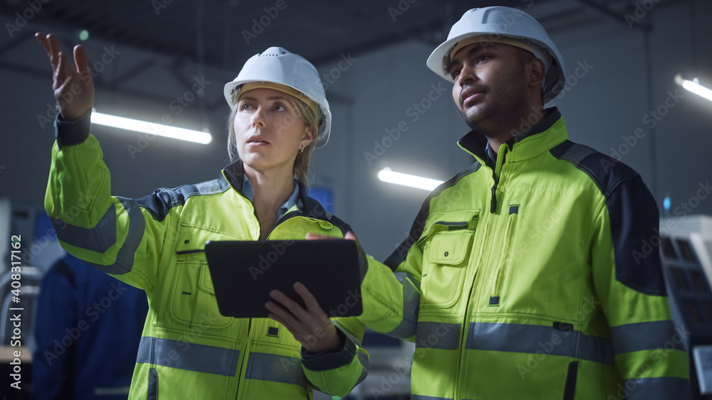 Aufkleber Chief Engineer and Project Manager Wearing Safety Vests and Hard Hats, Use Digital Tablet Computer in Modern Factory, Talking, Optimizing Production Line. Industrial Facility with CNC Machinery