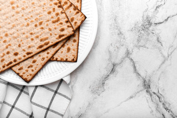 Plate with Jewish flatbread matza for Passover on light background