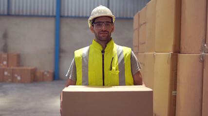 Smiling warehouse workers preparing a shipment in a large warehouse