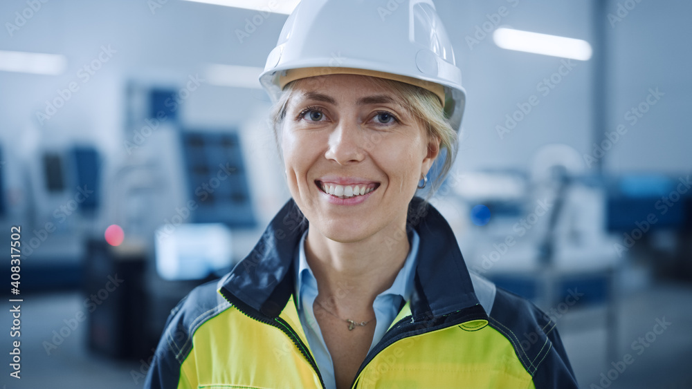 Poster portrait of beautiful smiling on camera female engineer in safety vest and hardhat. professional wom
