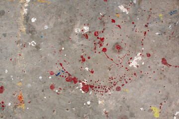 The floor is stained with several drops of various colors. Dripping paint on the concrete floor beautiful art. Droplets of red, black, and white stains on the ground. Multiple oil paint on background.
