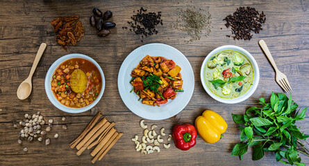 Vegetarian Sweet and Sour Vegetables and Vegetarian Massaman Curry and Vegetarian Thai Green Curry With spices around. Thai Food top view