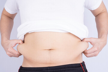 Fat man holding excessive fat belly, overweight fatty belly isolated grey background. Diet...