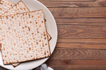 Plate with Jewish flatbread matza for Passover on wooden background