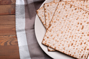 Plate with Jewish flatbread matza for Passover on wooden background