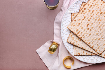 Plate with Jewish flatbread matza for Passover and cup of wine on color background