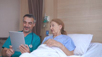 Doctor Talking To senior Patient with tablet