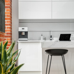 Black chair in white kitchen, close-up