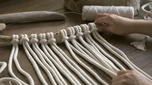 young woman relaxing making a macrame decoration