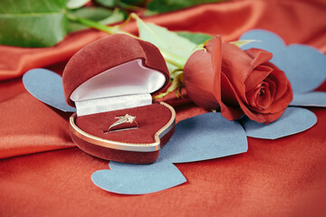 diamond ring and rose on bright red background