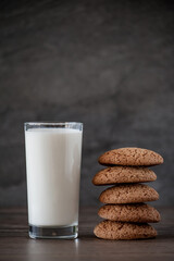 glass of milk and oatmeal cookies on a wooden table