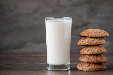 glass of milk and oatmeal cookies on a wooden table