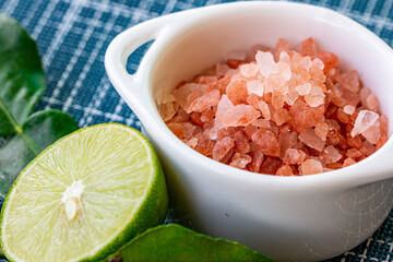 Fototapeta na wymiar bowl of pink Himalayan salt with fresh lime 