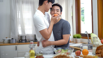 Gay couple homosexual cooking together in the kitchen