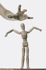 Concept of control. Marionette in human hand. Black and white.