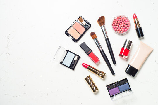 Makeup professional cosmetics, decorative cosmetic on white marble background. Flat lay image with copy space.