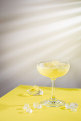 fresh banana and coconut tropical cocktail in a glass over yellow background