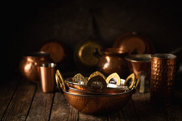Vintage copper dishes, pots and pans on dark wooden background