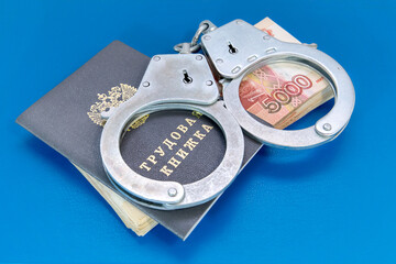 Labor book, handcuffs and money. Responsibility for violation of labor laws. Russian translation: Labor book
