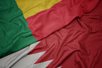 waving colorful flag of bahrain and national flag of benin.