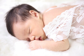 Obraz na płótnie Canvas Asian beautiful newborn baby eating milk and wearing in white dress was sleeping on a white soft blanket, Infant, babyhood concept and copy space - Image