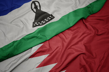 waving colorful flag of bahrain and national flag of lesotho.