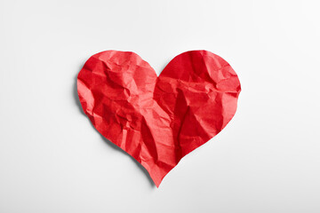 Crumpled red heart paper isolated on white background. Broken heart concept.