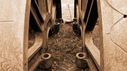 Two old and abandoned train's wheels side by side mirroring each other [Sepia colors]
