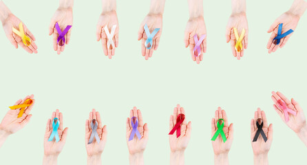 Women's hands hold multicolored ribbons, symbol of the fight against cancer. World cancer day
