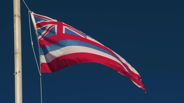 Hawaiian Flag including the British Flag. Captured in 4K in Hawaii, USA. The flag flaps its fabric in the wind, polarized dark blue skies. 4K.