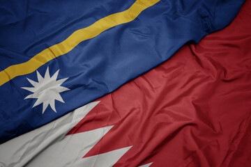 waving colorful flag of bahrain and national flag of Nauru .