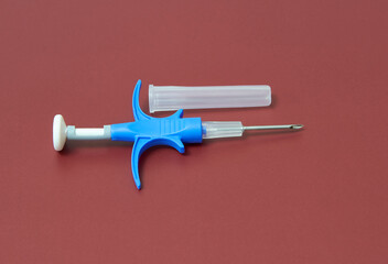 a syringe with a microchip for identifying animals on a brown background