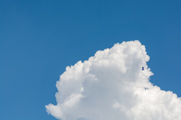 blue sky with white clouds and 
a faintly visible bugs bunny toy balloon soaring over the clouds - background hi-resolution