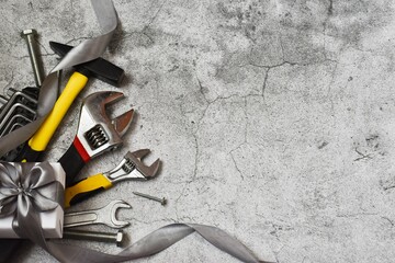 Father's Day Concept. Gift box and tools for repair and construction on gray concrete background. Copy space. Flat lay. Greeting card.