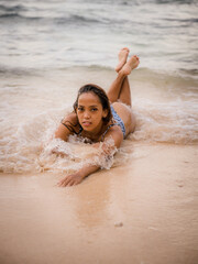 Fototapeta na wymiar Attractive woman lying on sandy beach near the ocean. Sexy body. Tanned skin. Asian woman wearing bikini. Summer concept. Vacation time. Lifestyle. Bali, Indonesia