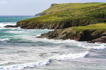 Fototapeta na wymiar coastal seascape with green headland ,rocky outcrops , golden empty beaches with waves and surf sea.