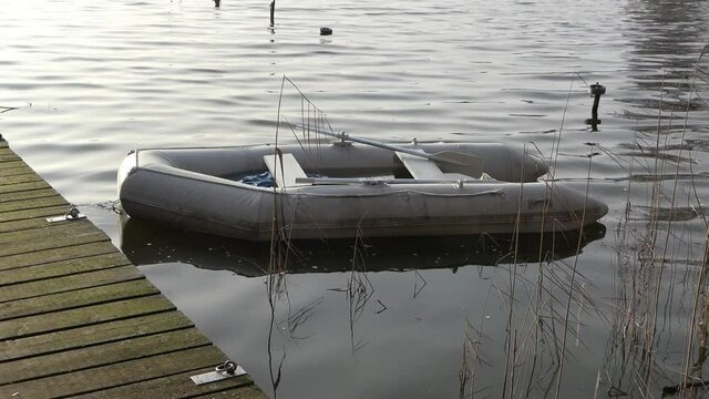 Dinghy inflatable boat in the water at a jetty in a northern German lake.