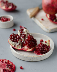 a cut garnet on a gray background with a knife and a board in the background
