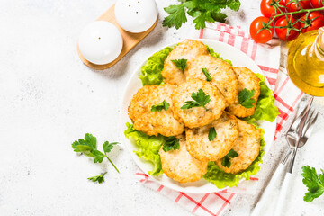 Chicken cutlet in white plate served at white stone table. Top view with copy space.