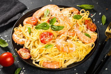 Pasta seafood. Spaghetti with shrimp and cream sauce at black background.