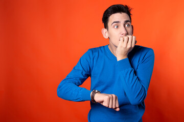 The young guy looks at the time. Expectation. Stormy emotions.