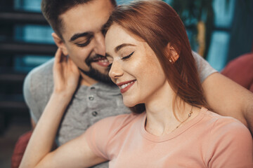 Adorable ginger woman with freckles is embracing her lover while dating on valentines day