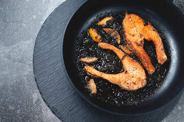 Juicy pan fried salmon steak on a natural slate stone table, close-up. Deliciously cooked salmon fillet. Flat-lay, top view