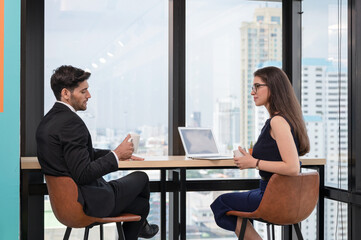 Caucasian businessperson colleague discussing and drinking on break in workplace at corner office