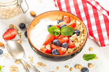 Greek yogurt granola with fresh berries on white stone table. Close up.