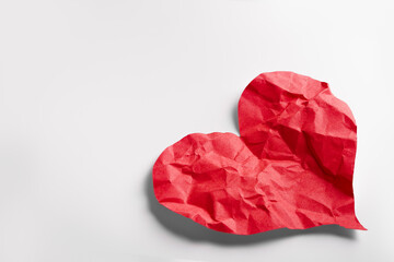 Crumpled red heart paper isolated on white background. Broken heart concept.