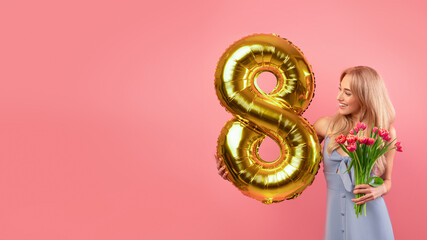 Carefree young lady with golden number eight balloon and bunch of tulips posing on pink background,...