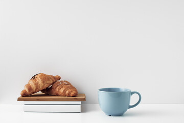 Mug and croissants on a white background. Eco-friendly and natural materials in the decor, dessert. Copy space, mock up.